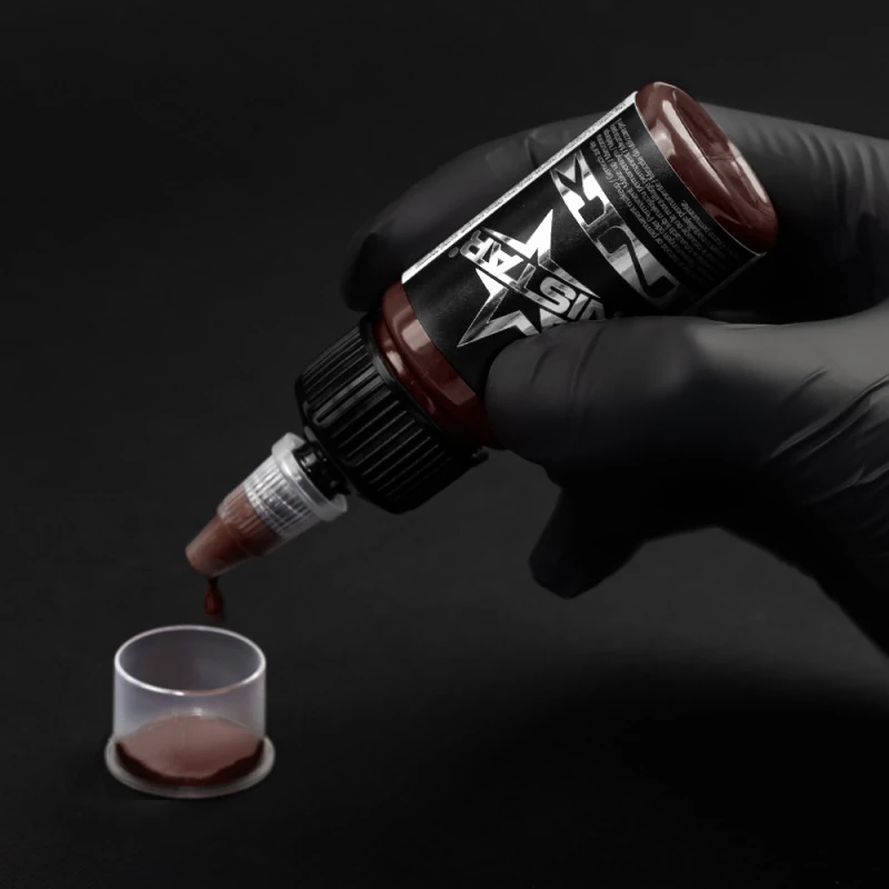 Unistar Chocolate Tattoofarbe wird mit Handschuh in eine Farbkappe gefüllt