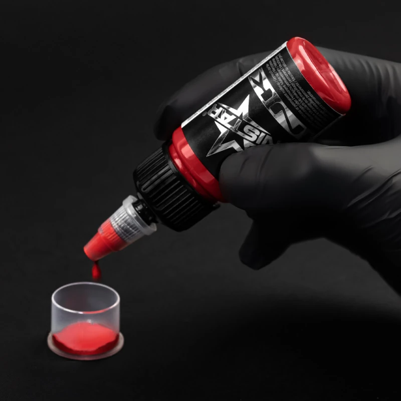 Unistar Top Basic Coral Tattoofarbe wird mit Handschuh in eine Farbkappe gefüllt