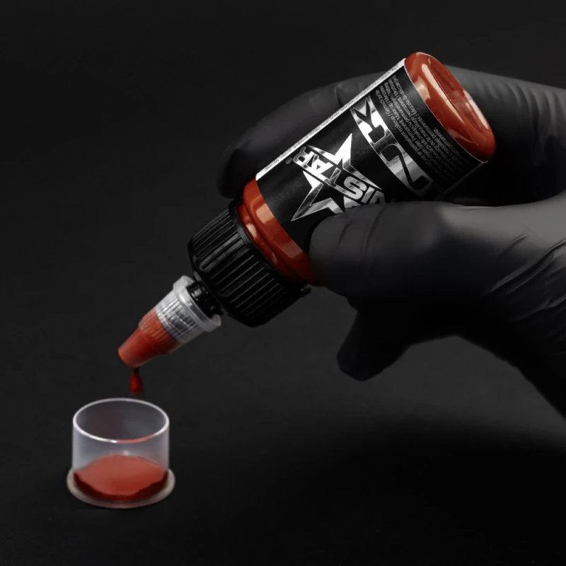 Unistar Tomato Red Tattoofarbe wird mit Handschuh in eine Farbkappe gefüllt