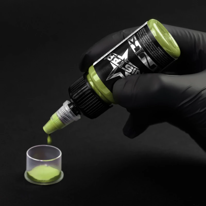 Unistar Green Whisper Tattoofarbe wird mit Handschuh in eine Farbkappe gefüllt
