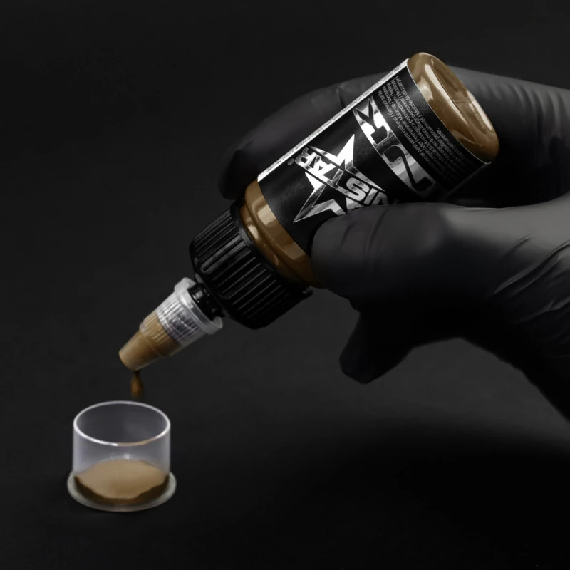 Unistar Light Brown Tattoofarbe wird mit Handschuh in eine Farbkappe gefüllt