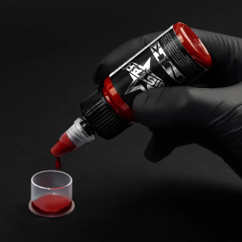 Unistar Top Basic Dark Red Tattoofarbe wird mit Handschuh in eine Farbkappe gefüllt