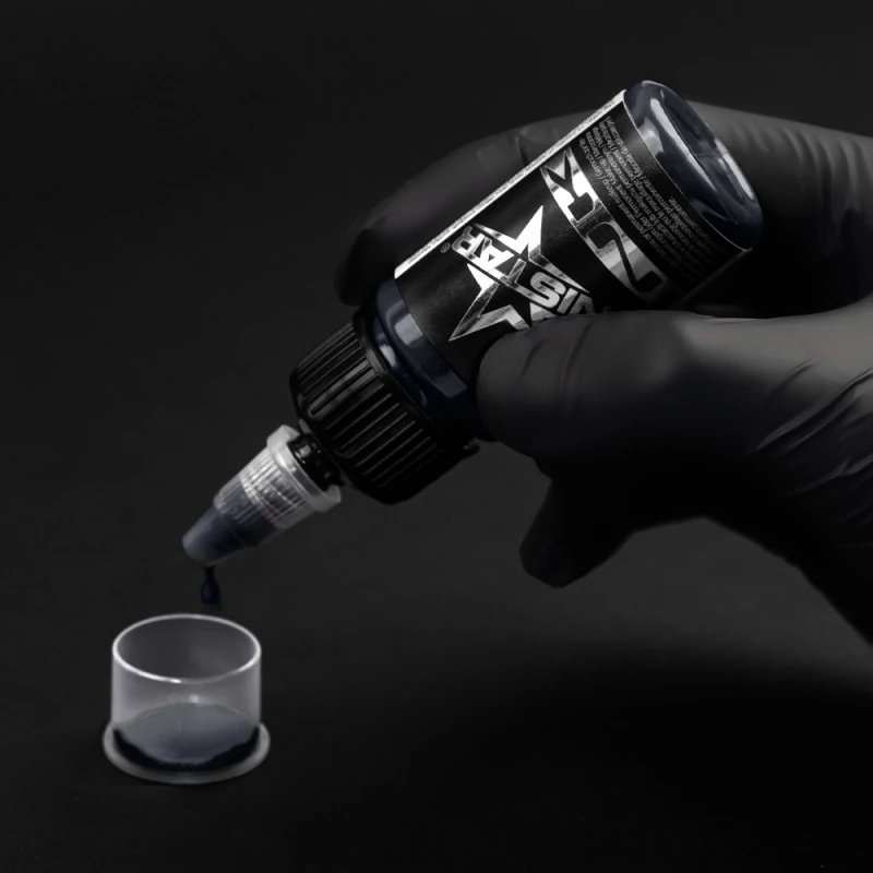 Unistar Blue Gray 5 Tattoofarbe wird mit Handschuh in eine Farbkappe gefüllt