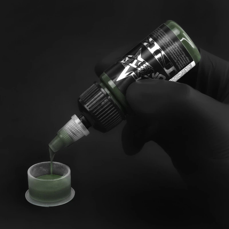 Unistar Dark Green Tattoofarbe wird mit Handschuh in eine Farbkappe gefüllt