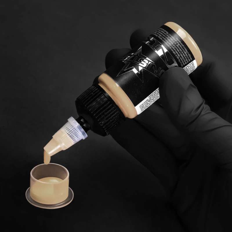 Unistar Beige Tattoofarbe wird mit Handschuh in eine Farbkappe gefüllt