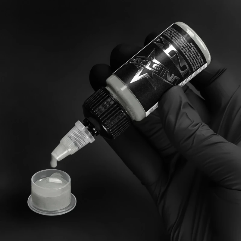 Unistar Solid Gray #1 Tattoofarbe wird mit Handschuh in eine Farbkappe gefüllt