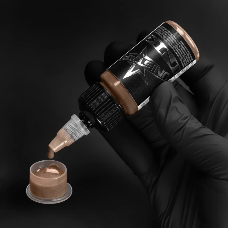 Unistar Skintone 3 Tattoofarbe wird mit Handschuh in eine Farbkappe gefüllt