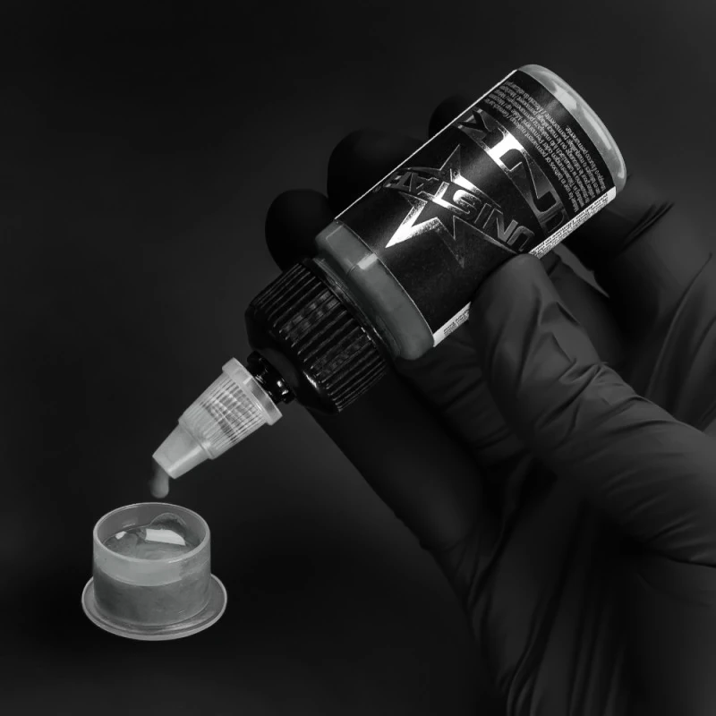 Unistar Solid Gray #2 Tattoofarbe wird mit Handschuh in eine Farbkappe gefüllt